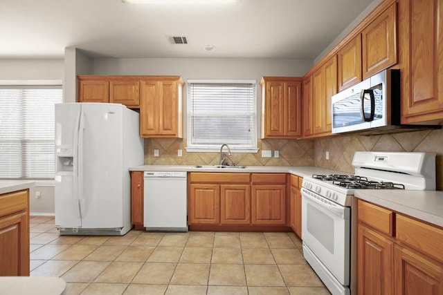 19907 Kennemer Dr, Pflugerville, TX 78660 - kitchen featuring white appliances, light countertops, plenty of natural light, and backsplash