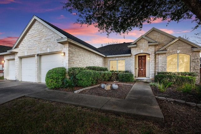 french provincial home with a garage, driveway, and roof with shingles