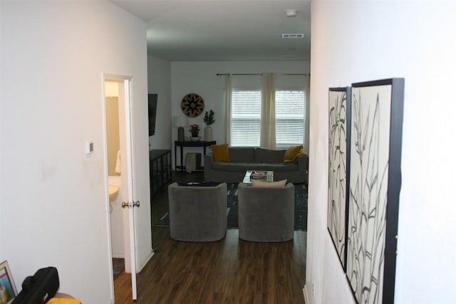 living area featuring visible vents and dark wood-type flooring