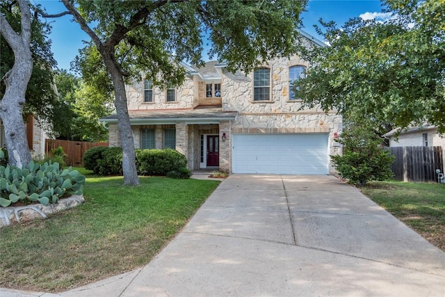 traditional-style house featuring stone siding, fence, concrete driveway, and a front yard