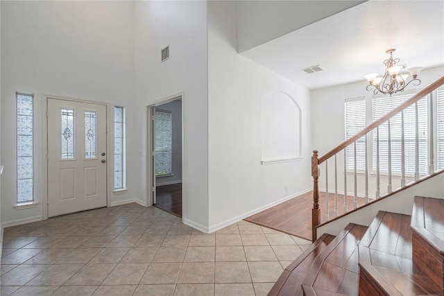 6205 York Bridge Cir, Austin, TX 78749 - foyer featuring a chandelier, light tile patterned floors, baseboards, and stairway