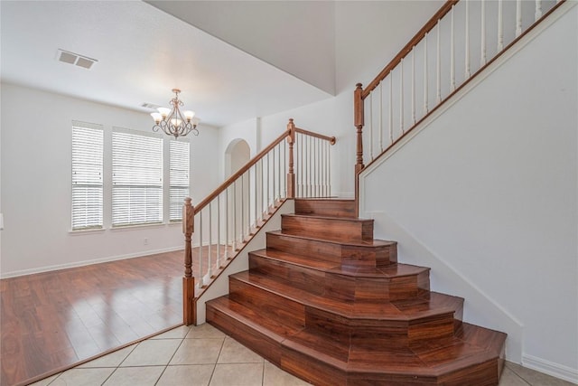 6205 York Bridge Cir, Austin, TX 78749 - stairs featuring a chandelier, baseboards, and tile patterned floors