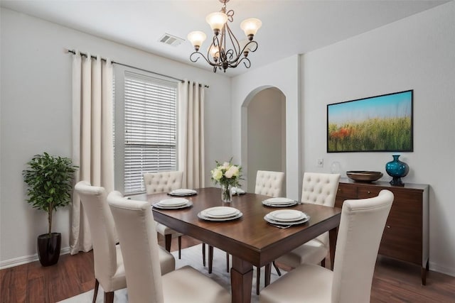 6205 York Bridge Cir, Austin, TX 78749 - dining room featuring arched walkways, a chandelier, wood finished floors, and baseboards