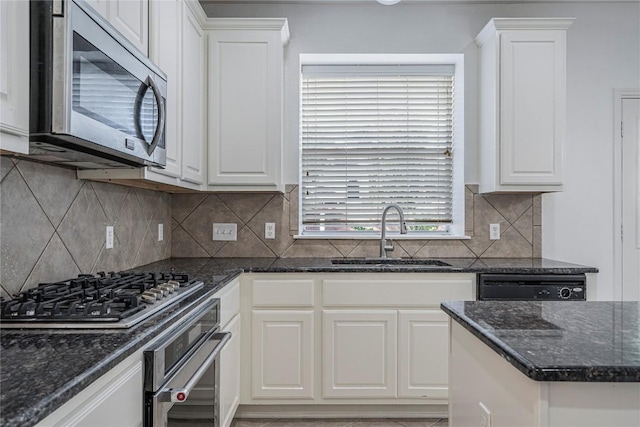 kitchen featuring appliances with stainless steel finishes, a sink, and white cabinets