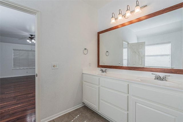 full bathroom featuring ceiling fan, a sink, baseboards, and double vanity