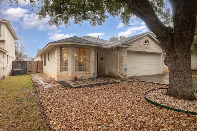 ranch-style house with a garage, stone siding, roof with shingles, and fence