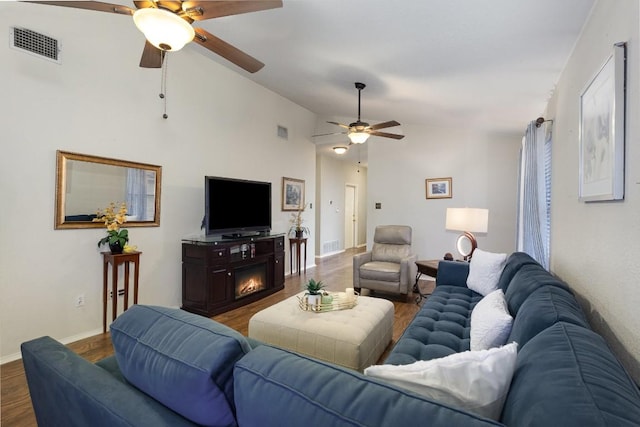 living room featuring lofted ceiling, wood finished floors, and visible vents