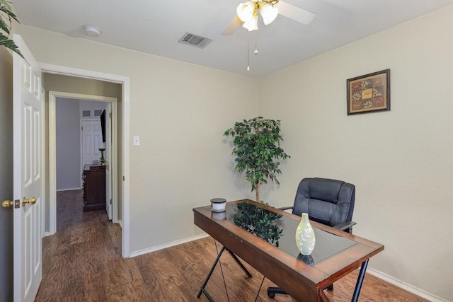 office space with dark wood-style floors, baseboards, visible vents, and a ceiling fan