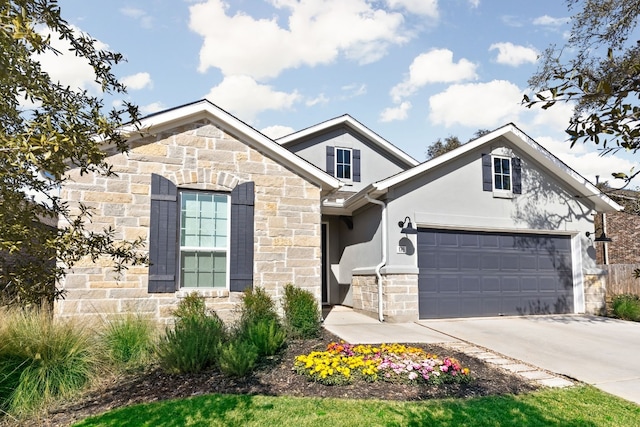 view of front of house with a garage, stone siding, concrete driveway, and stucco siding