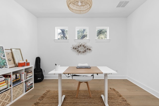 office space with light wood-style flooring, baseboards, and visible vents