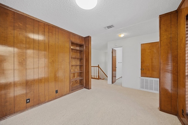 11512 Tin Cup Dr Unit 211, Austin, TX 78750 - carpeted empty room with wooden walls, a textured ceiling, and built in features