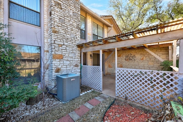 11512 Tin Cup Dr Unit 211, Austin, TX 78750 - view of side of property with stone siding, central AC unit, a pergola, and a patio