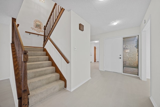 11512 Tin Cup Dr Unit 211, Austin, TX 78750 - stairs featuring a textured ceiling and baseboards