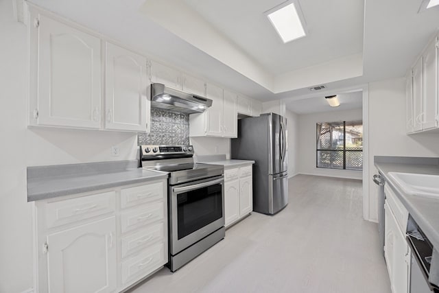 11512 Tin Cup Dr Unit 211, Austin, TX 78750 - kitchen featuring stainless steel appliances, under cabinet range hood, a raised ceiling, and white cabinetry