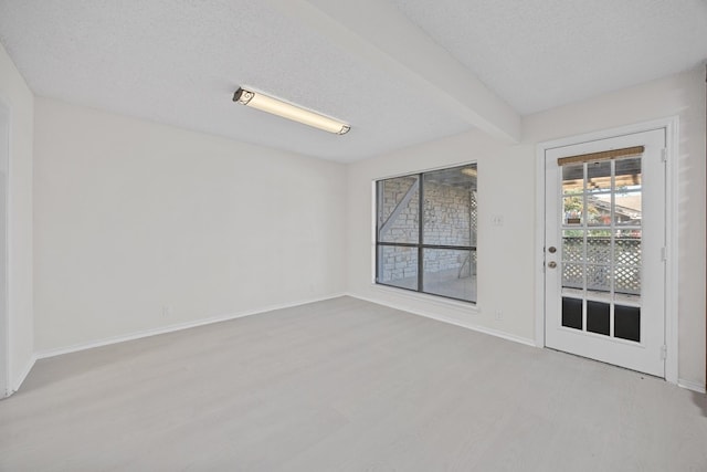 11512 Tin Cup Dr Unit 211, Austin, TX 78750 - unfurnished room featuring light wood-type flooring, beam ceiling, baseboards, and a textured ceiling
