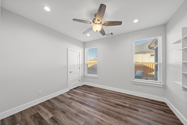 spare room featuring baseboards, visible vents, a ceiling fan, dark wood-style floors, and recessed lighting