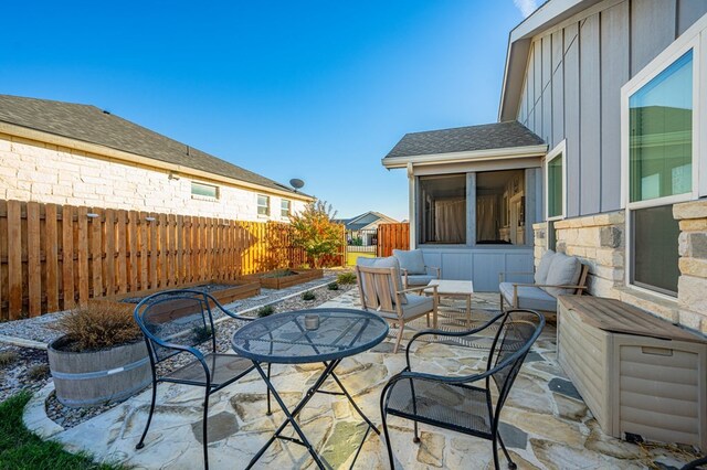 view of patio / terrace featuring outdoor lounge area, a fenced backyard, and a sunroom