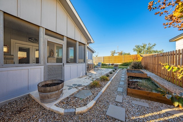 view of yard featuring a garden, a fenced backyard, and a patio