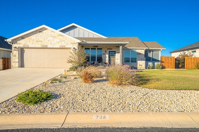 single story home with board and batten siding, concrete driveway, stone siding, and a garage