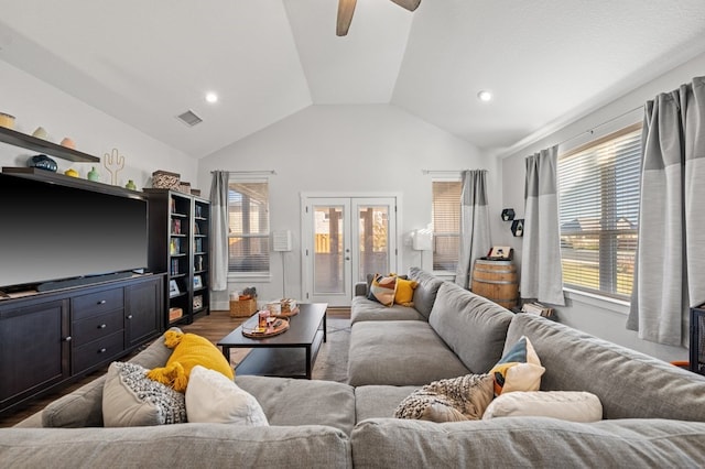 living room with lofted ceiling, wood finished floors, visible vents, a ceiling fan, and french doors