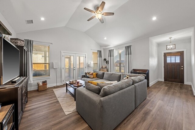 living area featuring lofted ceiling, dark wood-style flooring, visible vents, and ceiling fan