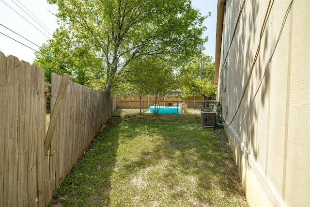 view of yard featuring central AC unit and a fenced backyard