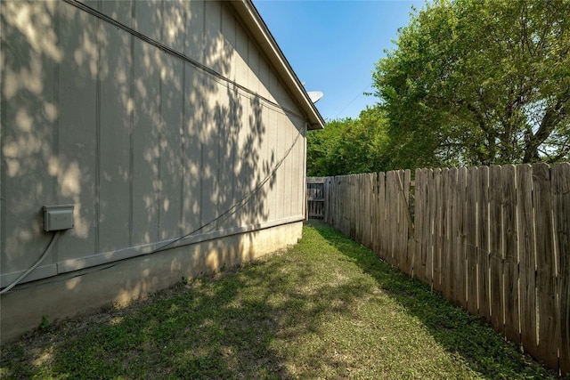 view of home's exterior featuring a lawn and fence