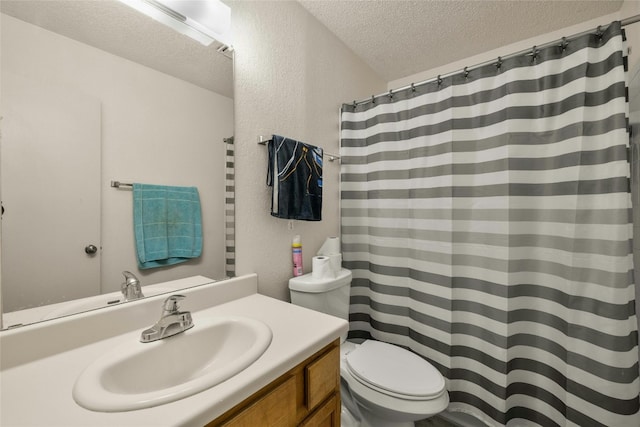 full bathroom with a textured ceiling, a textured wall, toilet, and vanity