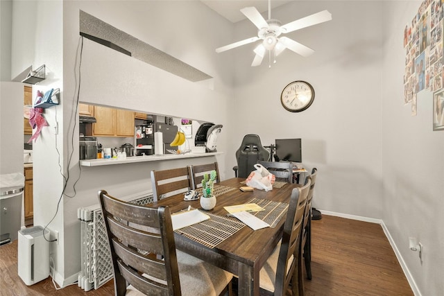 dining room featuring dark wood-type flooring, a ceiling fan, and baseboards