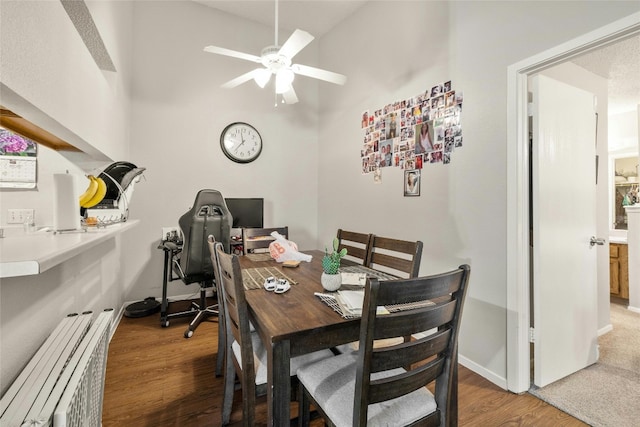 dining room featuring a ceiling fan, baseboards, and wood finished floors