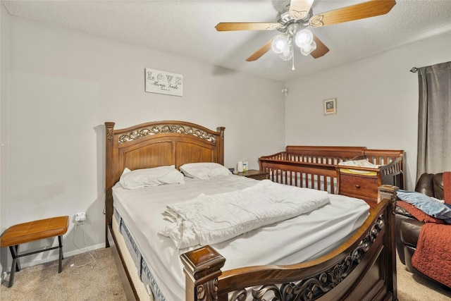 bedroom featuring light carpet, a textured ceiling, a ceiling fan, and baseboards