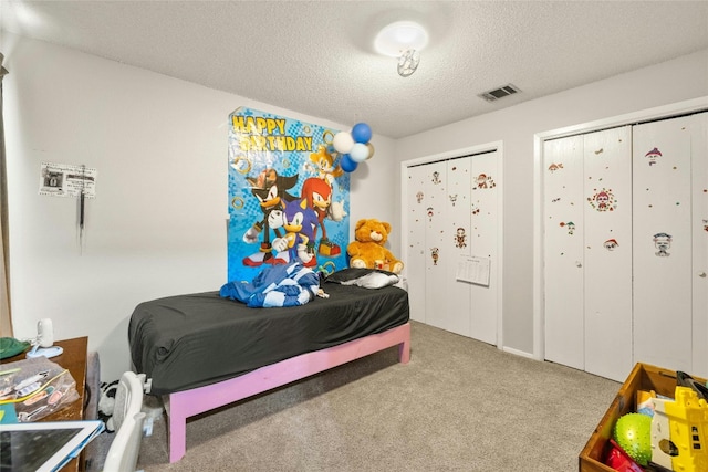 carpeted bedroom featuring visible vents and a textured ceiling