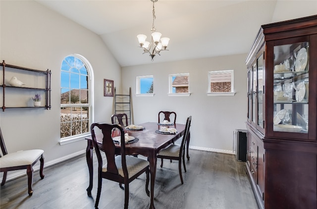 dining room featuring dark wood-style flooring, a notable chandelier, vaulted ceiling, and baseboards