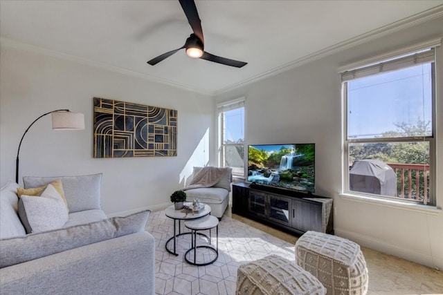 living area with baseboards, a ceiling fan, and crown molding