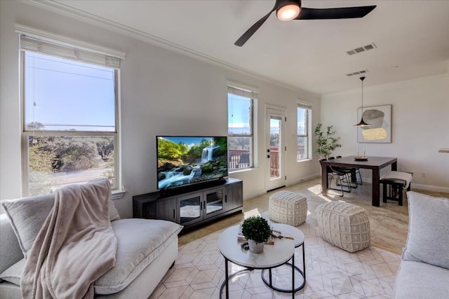 living area featuring ceiling fan, ornamental molding, and visible vents