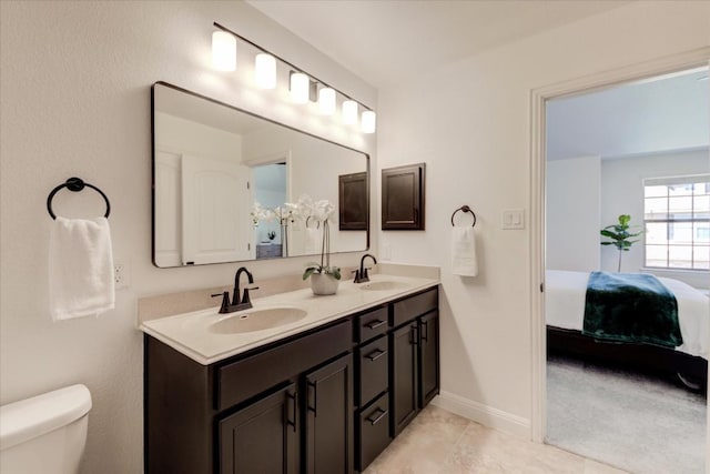 full bathroom featuring toilet, connected bathroom, a sink, and double vanity