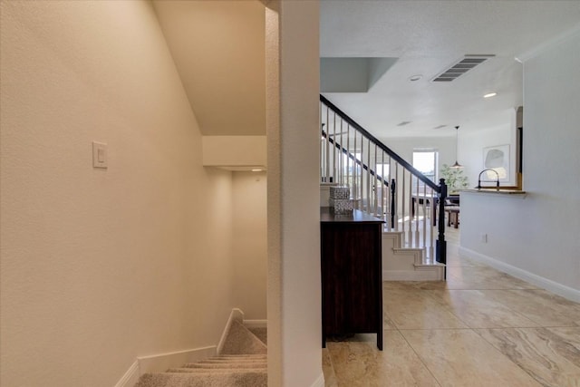 staircase featuring tile patterned flooring, visible vents, and baseboards