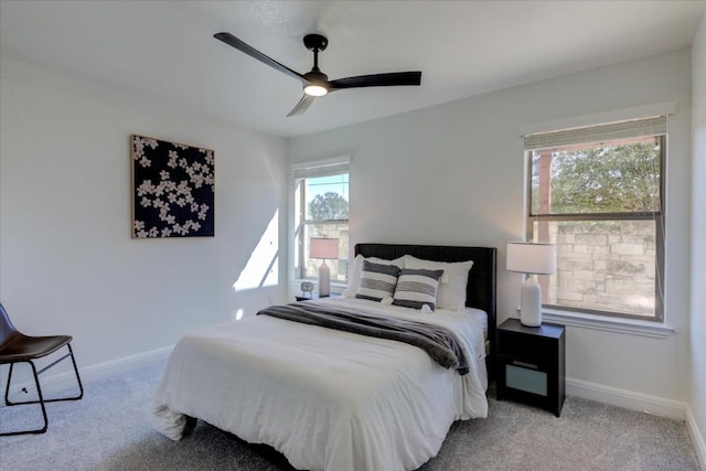 bedroom with a ceiling fan, light carpet, and baseboards