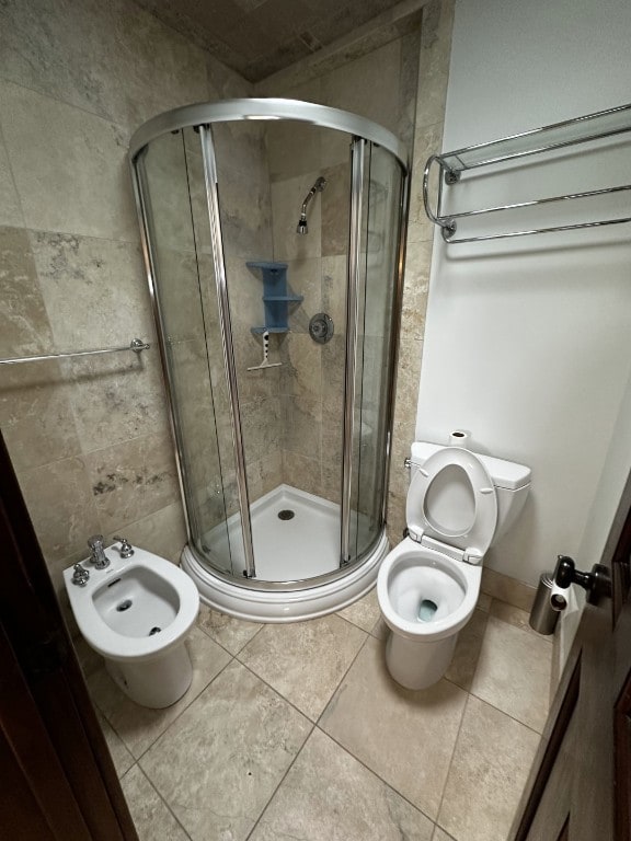 full bathroom with a bidet, tile patterned floors, toilet, and a stall shower