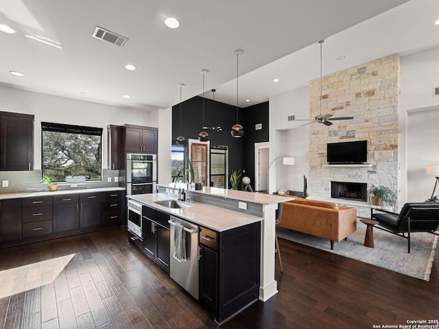 5922 Keller Rdg, New Braunfels, TX 78132 - kitchen with appliances with stainless steel finishes, light countertops, dark wood-type flooring, a fireplace, and a ceiling fan