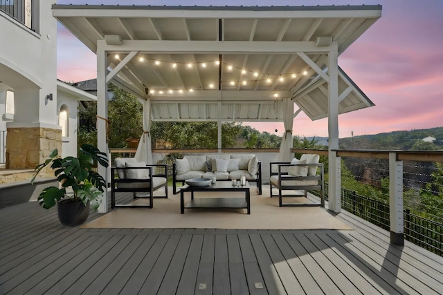 deck at dusk featuring an outdoor hangout area