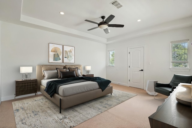 bedroom featuring a tray ceiling, recessed lighting, visible vents, and baseboards