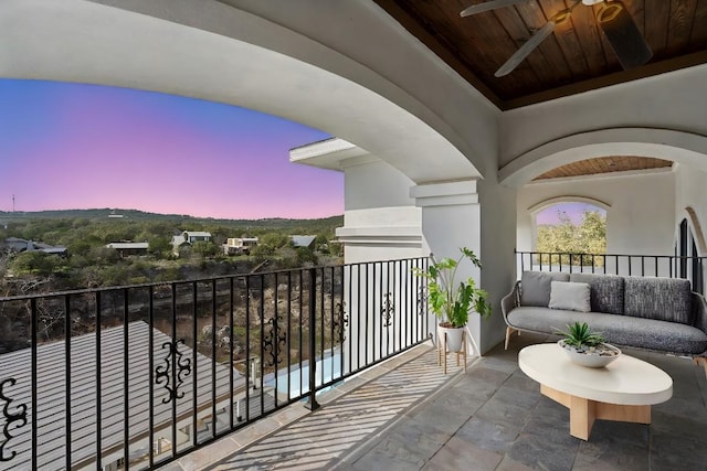 balcony at dusk with an outdoor hangout area and a ceiling fan