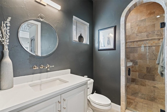 bathroom with a stall shower, vanity, and toilet