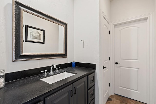 bathroom featuring stone finish flooring and vanity