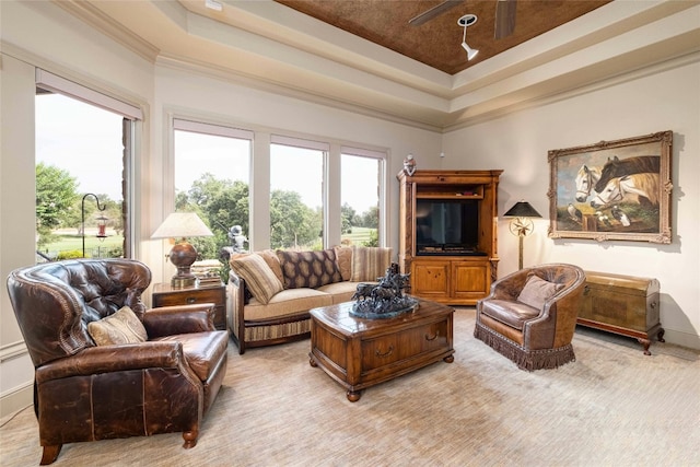 living area with baseboards, a raised ceiling, carpet flooring, and crown molding