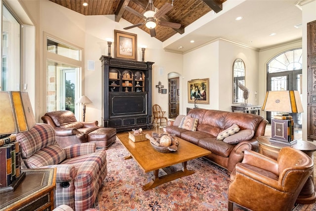 living room featuring beamed ceiling, high vaulted ceiling, a ceiling fan, wood ceiling, and arched walkways