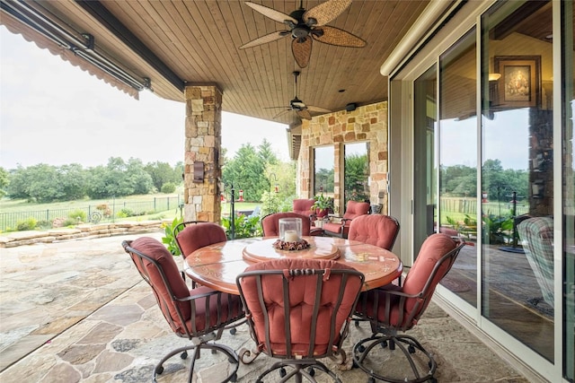 view of patio with fence, outdoor dining space, and ceiling fan