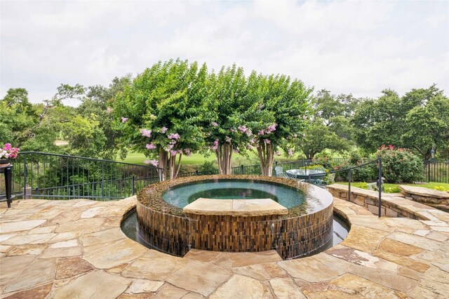 exterior space with fence, a hot tub, and a patio area