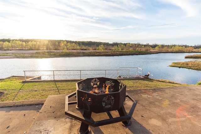 exterior space featuring a water view, an outdoor fire pit, and fence